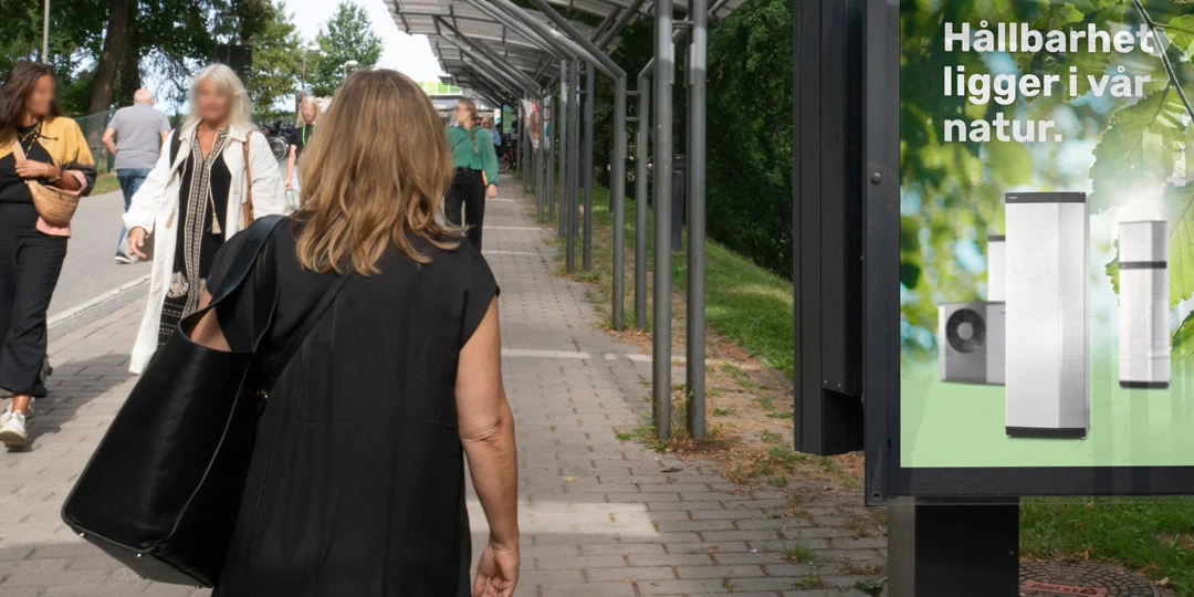 Besökare på gångvägen mot Stockholmsmässan, med skyltning vid sidan.