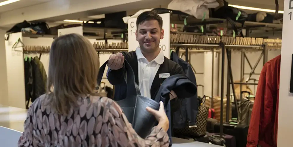 Inför ditt besök på Totalförsvarsmässan: Personal tar emot en väska i garderoben på Stockholmsmässan