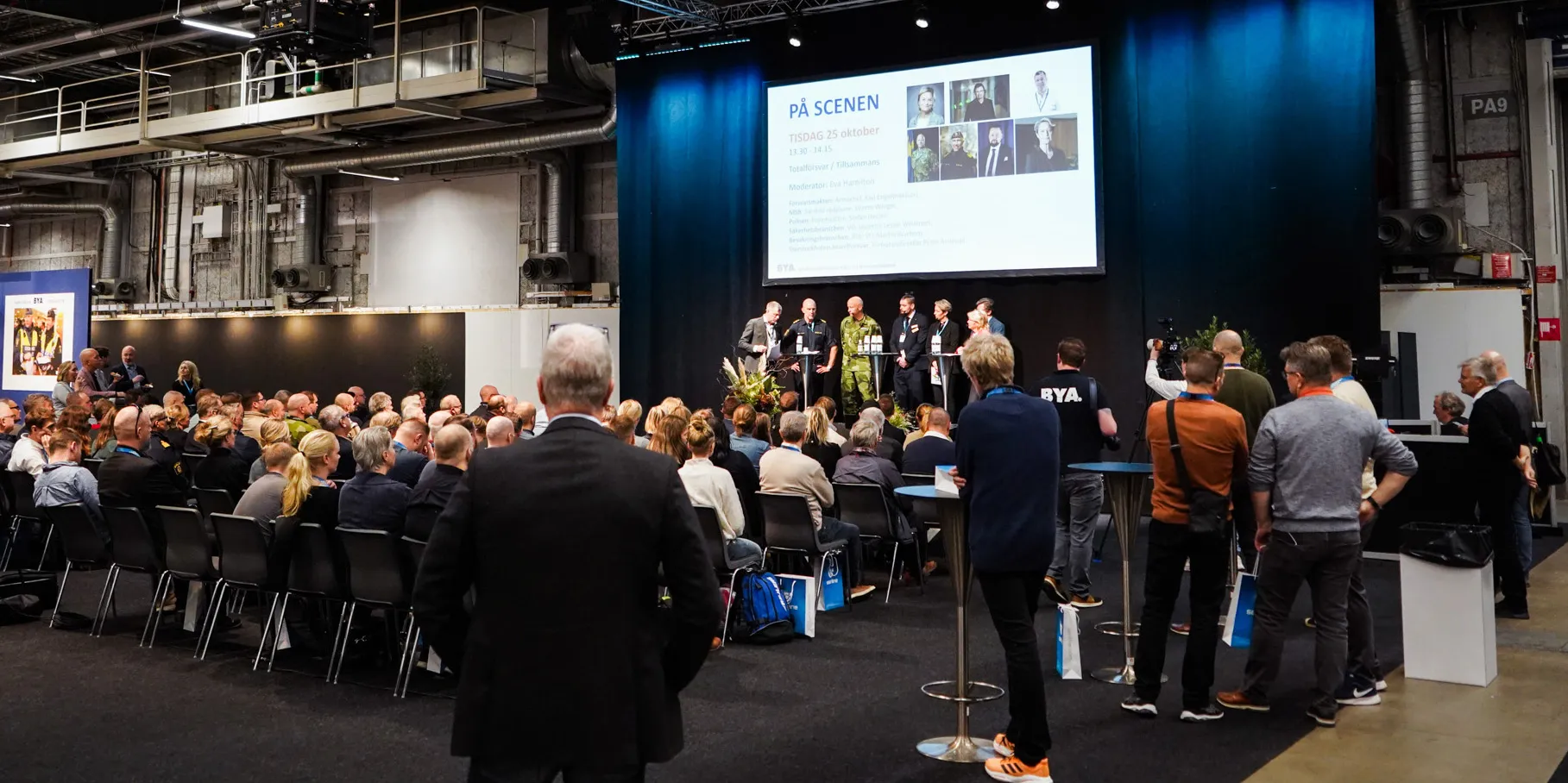 Besökare framför en scen under programmet på Totalförsvarsmässan.